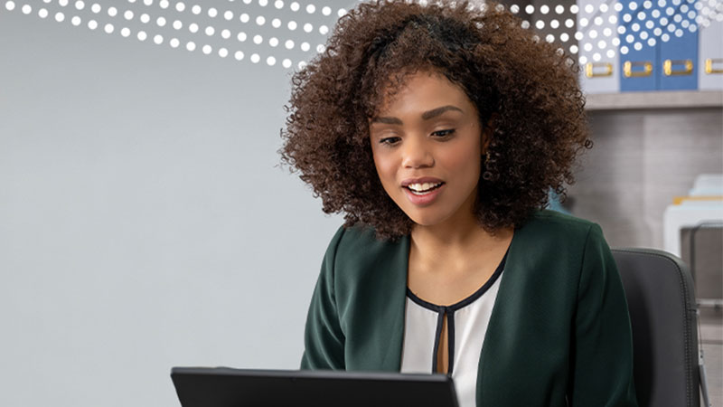 A female office worker looks at her laptop screen