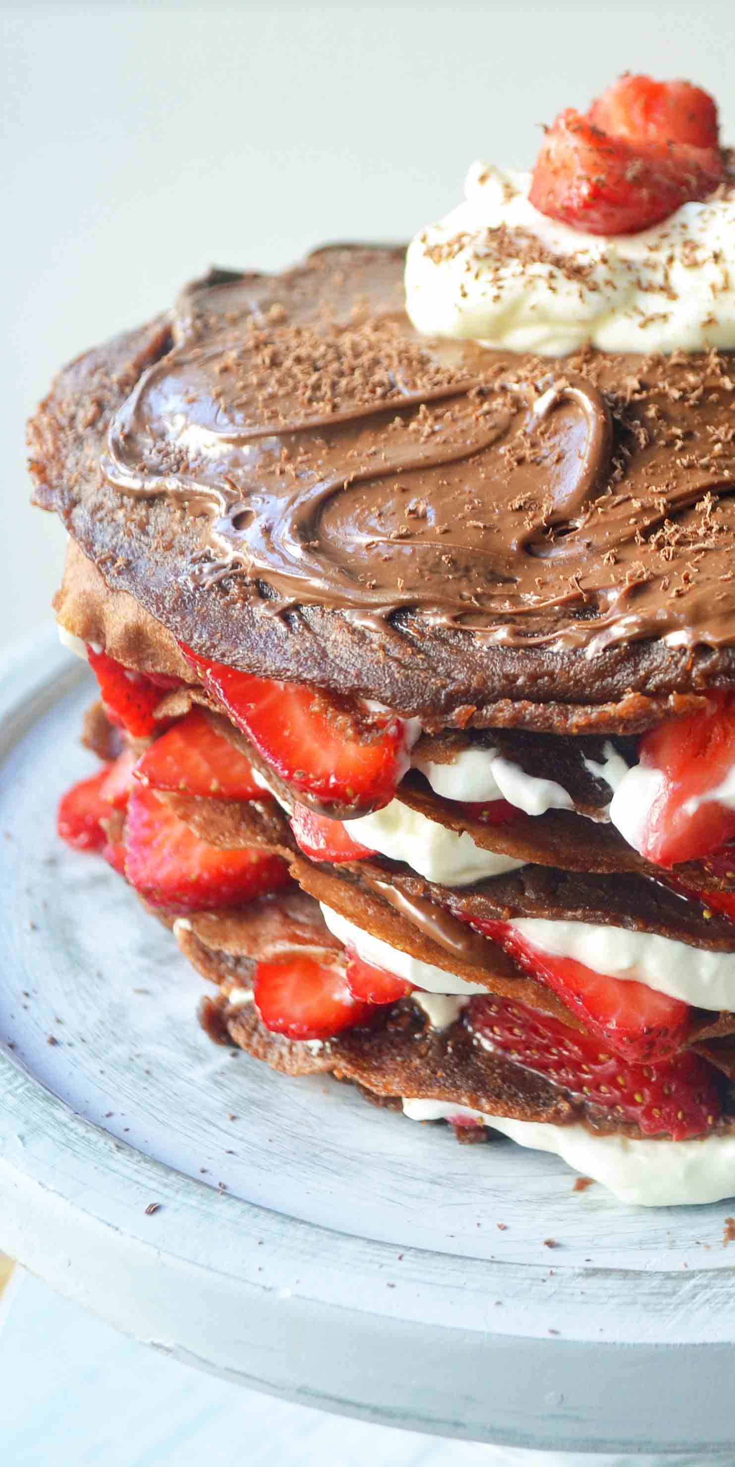 Strawberry Nutella Chocolate Crepe Cake. Layers of chocolate crepes, whipping cream, nutella, and fresh strawberries.