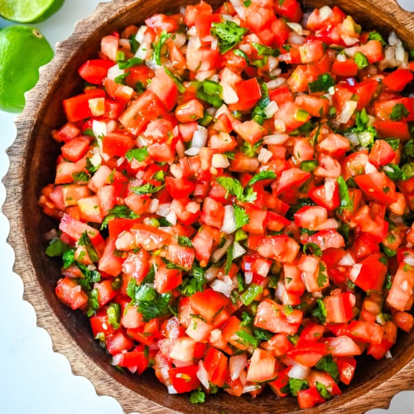 How to make fresh homemade pico de gallo made with the freshest ingredients -- fresh tomatoes, onion, cilantro, jalapeños, and lime juice. It is delicious on tacos, burritos, grilled meats, or as a simple fresh salsa with tortilla chips. It is super easy to whip up and is made with only six ingredients.