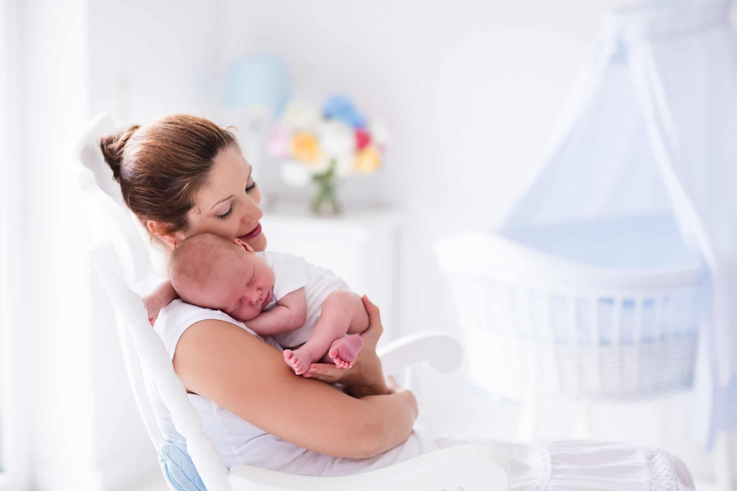 Young mother holding her newborn child. Mom is nursing the baby.