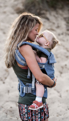 mum hugging cute toddler at the beach