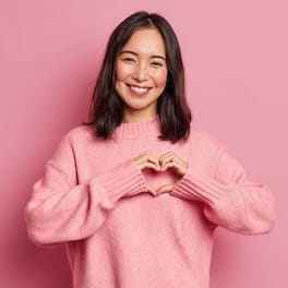 Woman smiling and making heart symbol with her hands