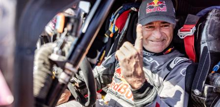 Carlos Sainz levanta el dedo, triunfal, tras conseguir su cuarto triunfo absoluto en el Rally Dakar, todos ellos al volante de marcas distintas