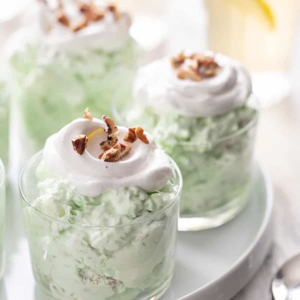 Three small serving dishes filled with watergate salad set on a white platter