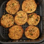 Cooked crispy eggplant in an air fryer basket.