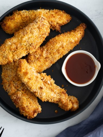 chicken tenders on plate with sauce on side