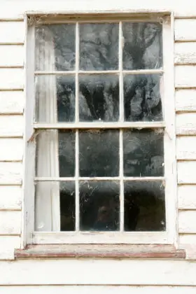 old window in white wooden weatherboard wall