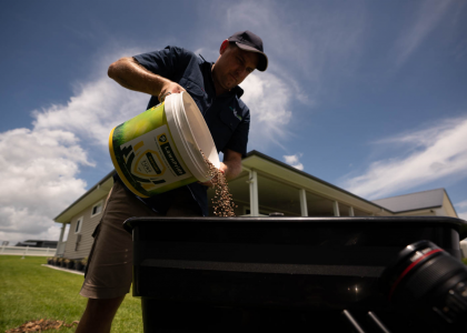 Man preparing to fertilise his lawn with myhomeTURF.