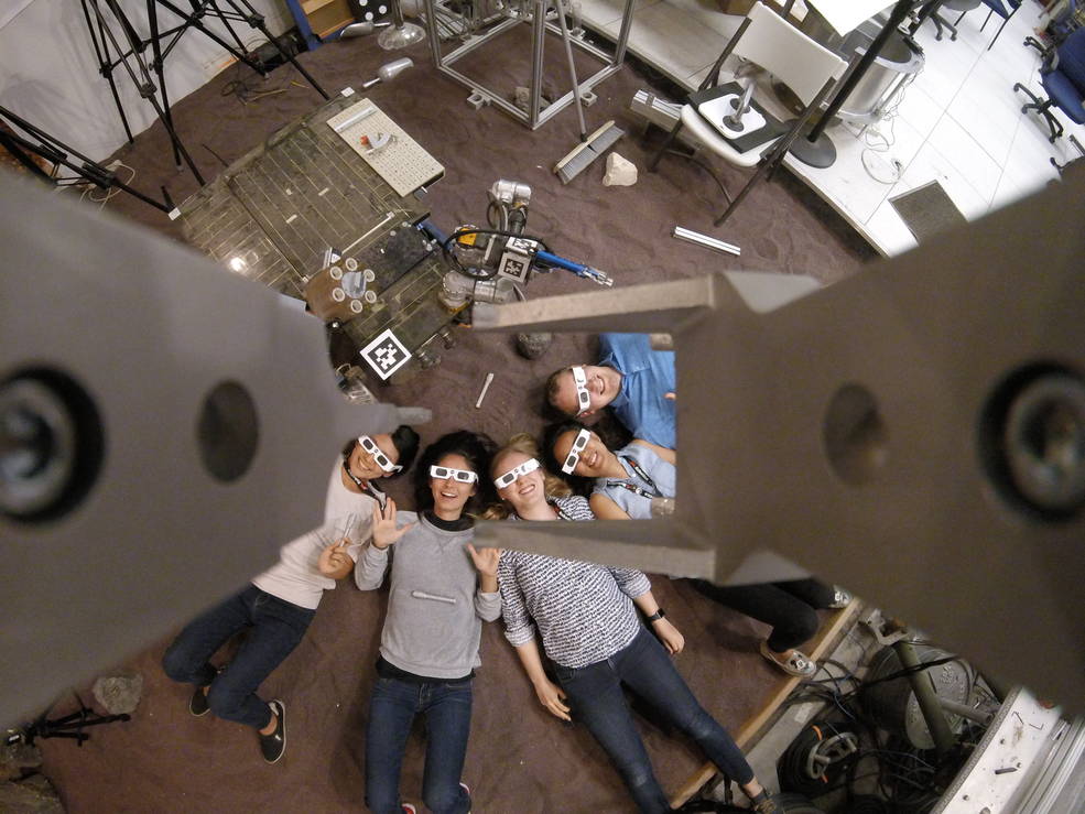 Students at NASA's Jet Propulsion Laboratory pose for photos around the laboratory wearing their eclipse glasses.