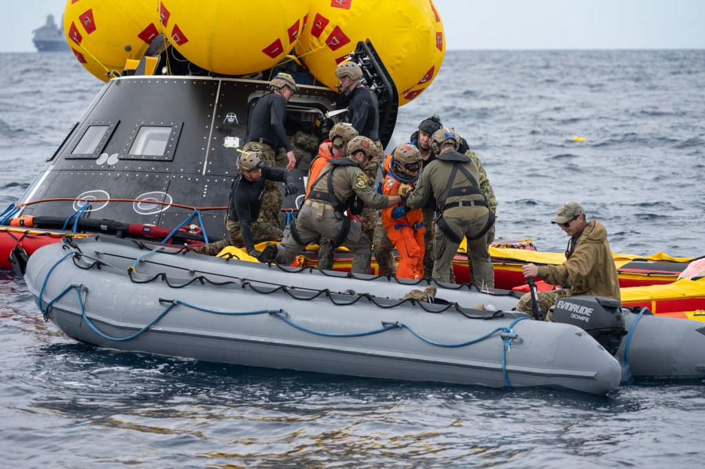 NASA Artemis II crew members are assisted by U.S. Navy personnel as they exit a mockup of the Orion spacecraft in the Pacific Ocean during Underway Recovery Test 11 (URT-11) on Sunday, Feb. 25, 2024. URT-11 is the eleventh in a series of Artemis recovery tests, and the first time NASA and its partners put their Artemis II recovery procedures to the test with the astronauts.