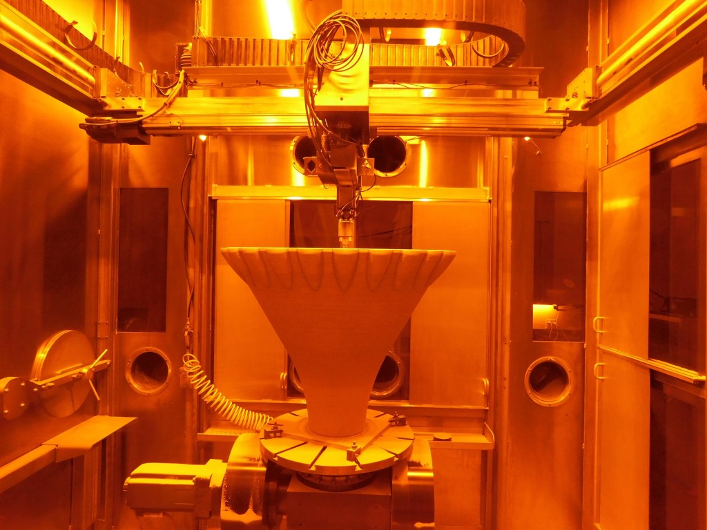 A 3D printer at RPM Innovations’ facility additively manufactures a funnel-shaped aerospike rocket engine nozzle