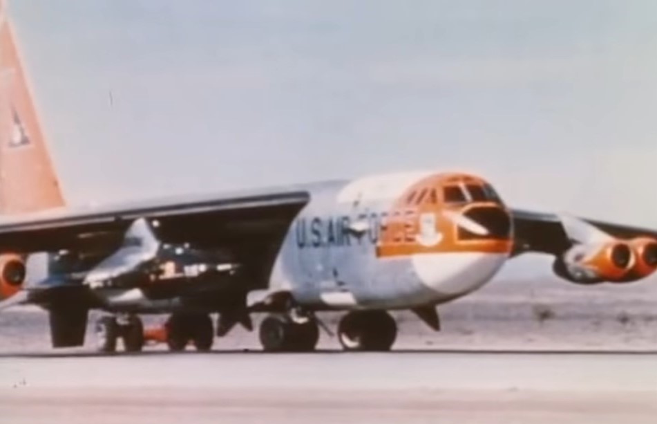 The B-52 carrier aircraft taxis on the runway at Edwards Air Force Base in California, with the X-15 and pilot A. Scott Crossfield ready to perform the first powered flight of the hypersonic research aircraft.