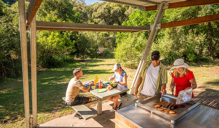 Campers cooking on the sheltered barbecue at Putty Beach campground. Photo: John Spencer/DPIE