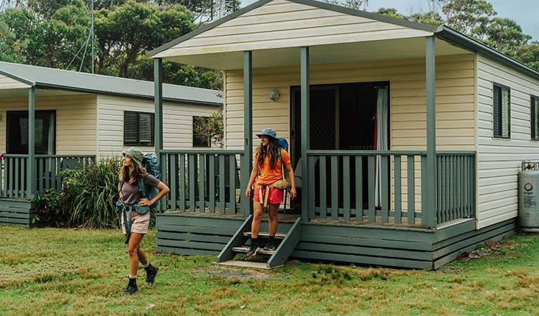 2 bushwalkers descending the steps from their Pretty Beach cabin, Murramarang National Park. Credit: Remy Brand &copy; Remy Brand