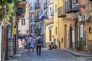 people walking along a street with colorful buildings