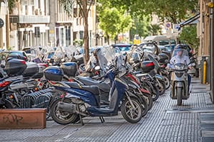 a man on a motor scooter looking for a parking space