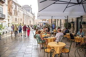 people sitting in a colorful cafe while seeing Sicily by car