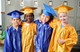 New Horizon Academy pre-kindergarten graduates wearing graduation caps and gowns and getting ready for kindergarten