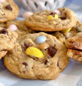 Pile of Cadbury Egg Chocolate Chip Cookies on a blue and white plaid napkin.