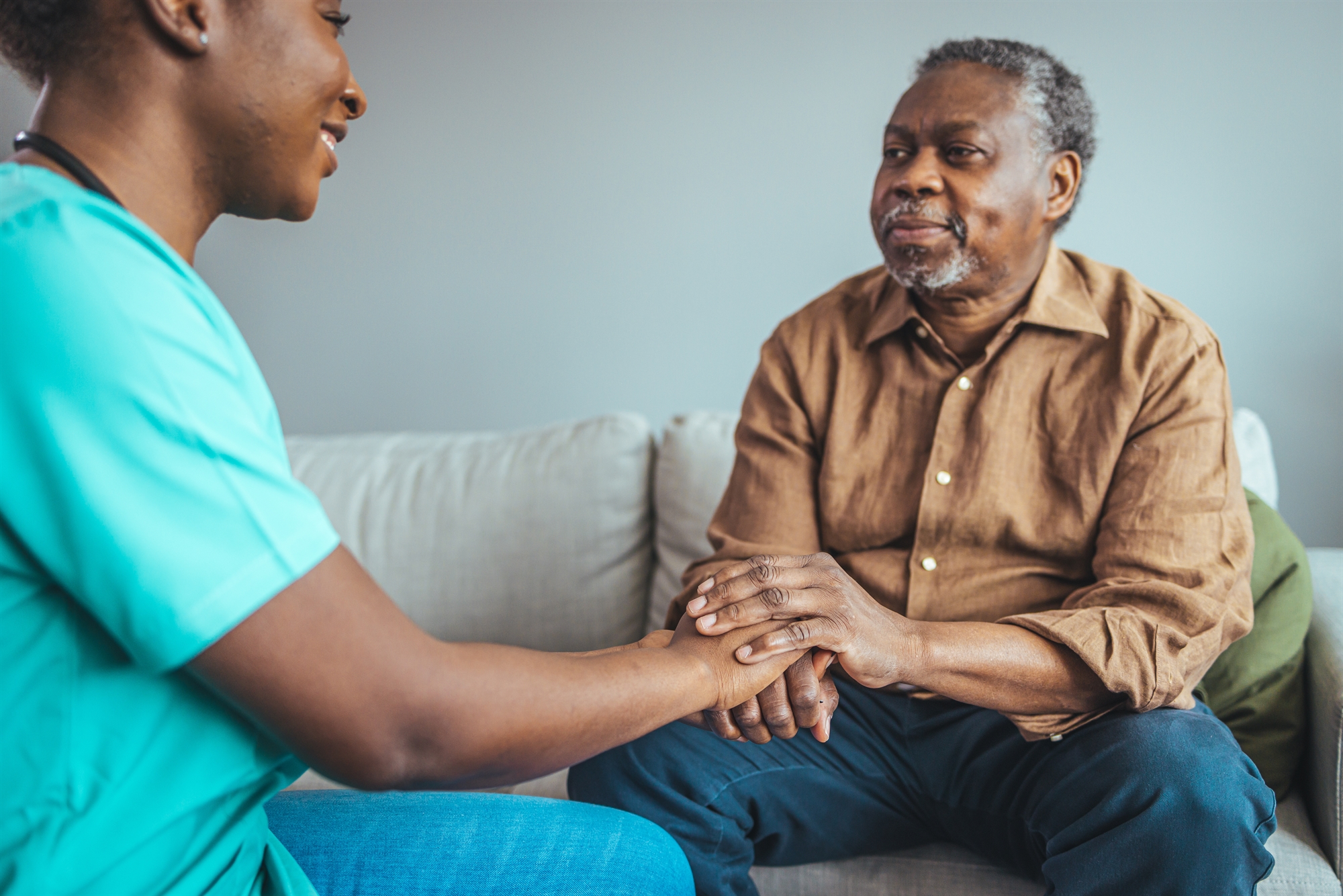 aid working holding hands with older man