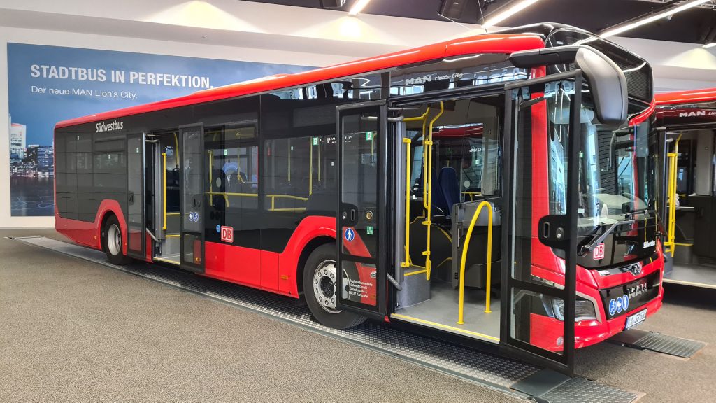 Roter Bus der DB, welcher ausgestellt in einer Halle steht. Die Türen des Busses sind geöffnet.