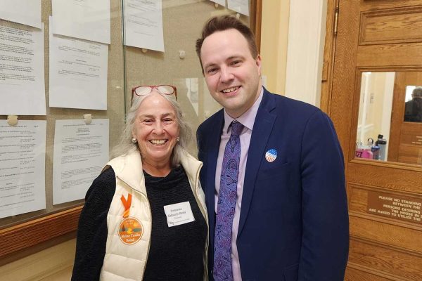 Two people smiling in halls of State House