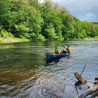 people paddling canoe in river