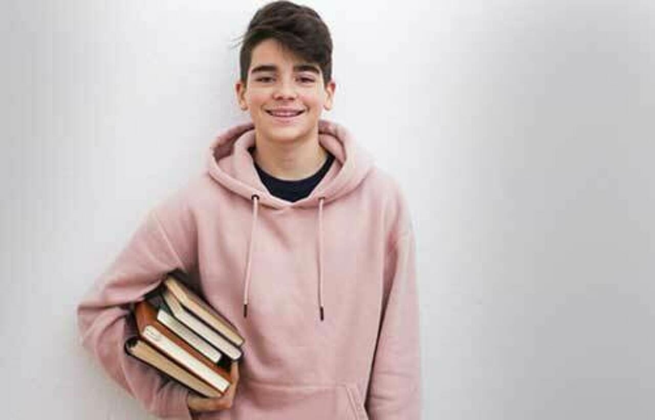 Junge mit Büchern unterm Arm. Foto: AdobeStock