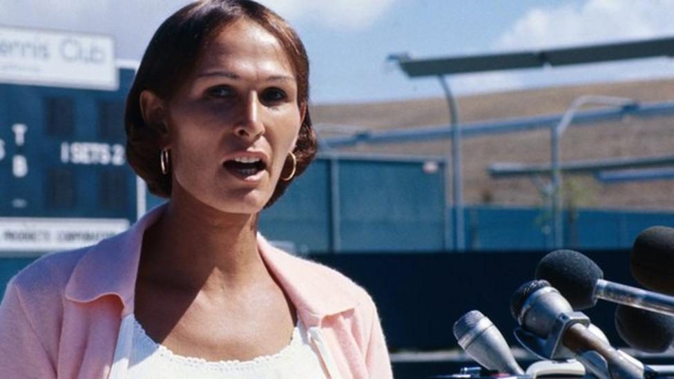 Renée Richards outside on tennis courts doing an interview