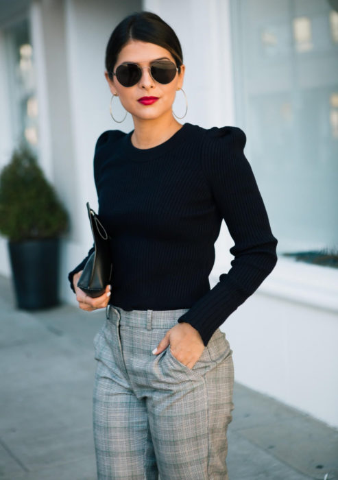 Atuendos formales y juveniles para oficina; mujer con lentes de sol, blusa negra con hombreras, pantalón gris a cuadros