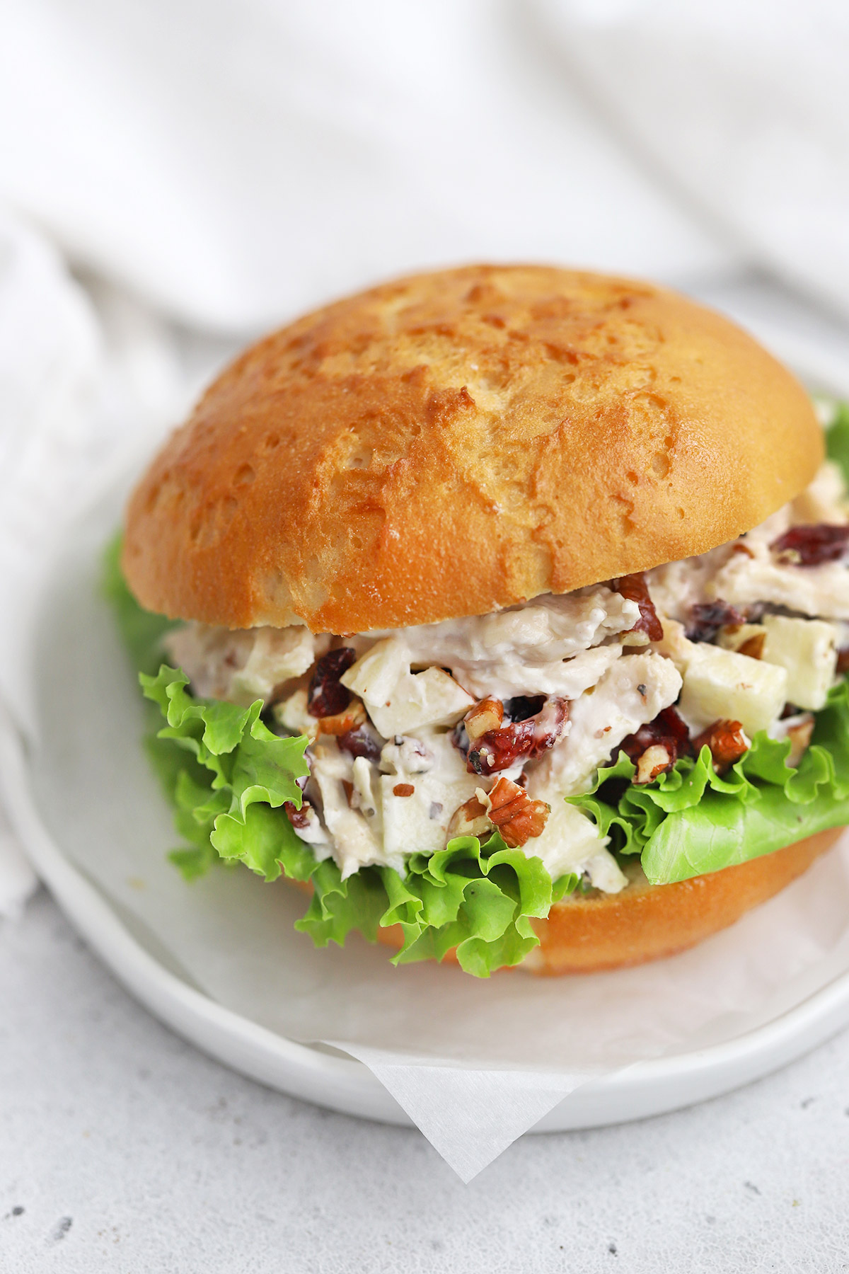 Close up view of an Apple Cranberry Chicken Salad Sandwich on a Gluten-Free Bun with Lettuce