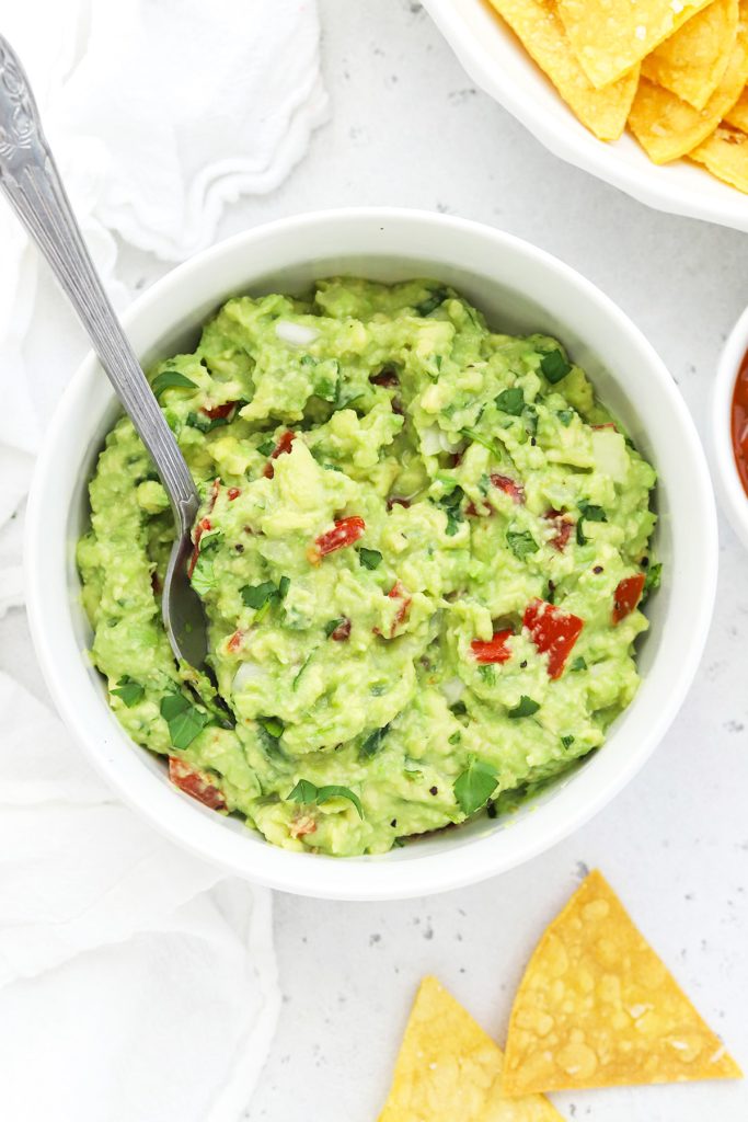 Overhead view of homemade guacamole with baked tortilla chips