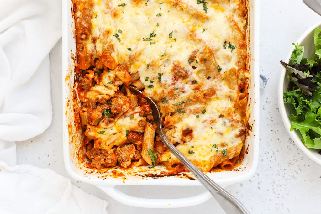 Overhead view of cheesy gluten-free baked ziti in a white baking dish