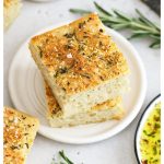 squares of gluten-free focaccia stacked on a white plate