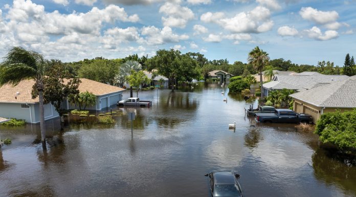 Hurricane rainfall flooded road. Drowned car on city street in Florida residential area. Consequences of hurricane natural disaster.