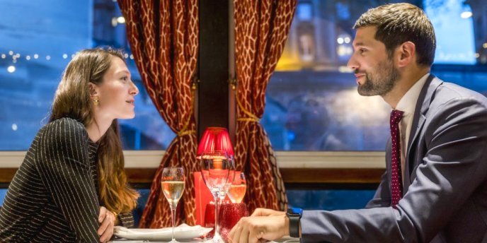 A couple gazing at each other across the table on Seine River Dinner Cruise by Maxim's of Paris 