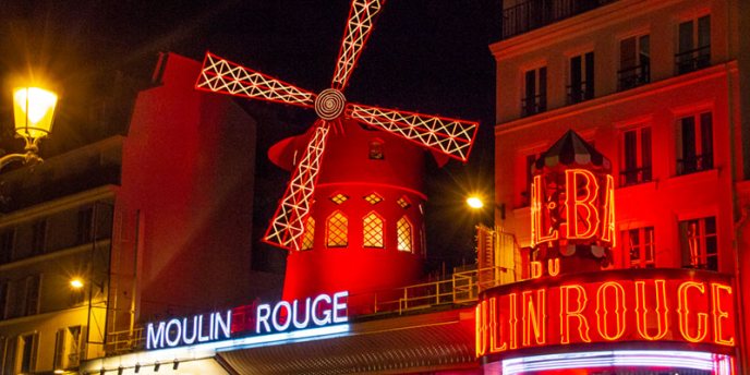 The windmill on the historic Moulin Rouge in Paris just before an evening of a Dinner + Show