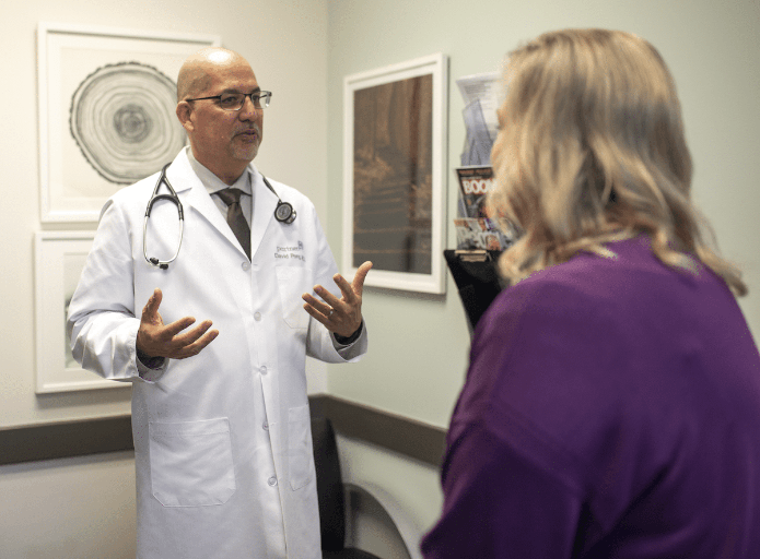 Dr. David Pong, Director of Executive Health at PartnerMD, talks with a female patient