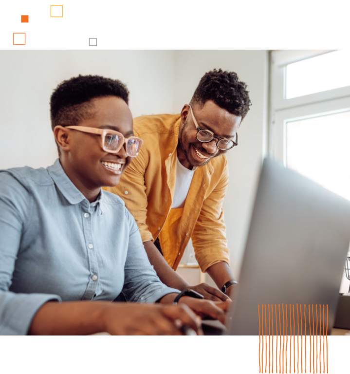 two smiling workers using a computer