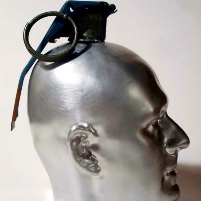 A sculpture of a silver human head made to look like a grenade.