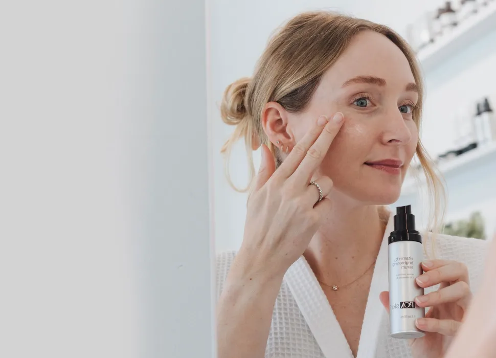 Women applying PCA SKIN serum to face