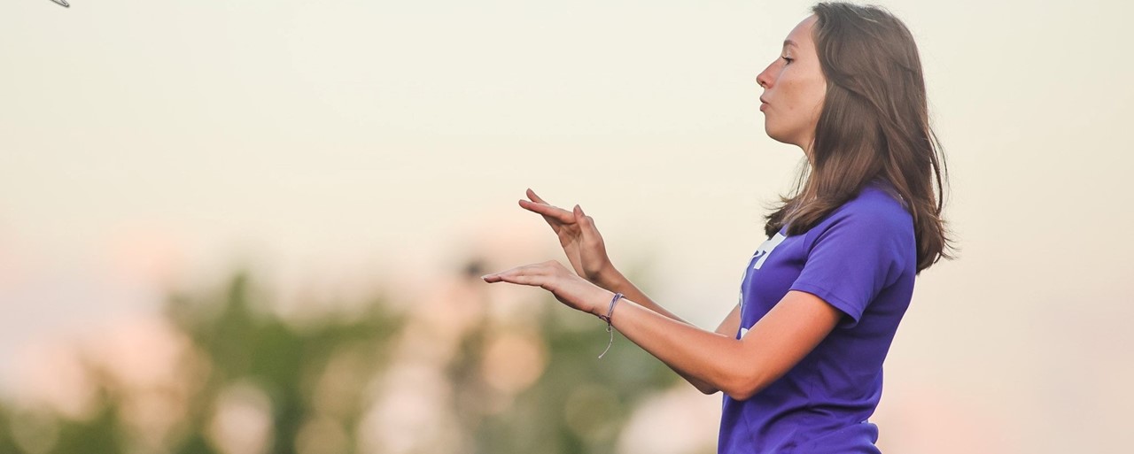 girl wearing purple directing music