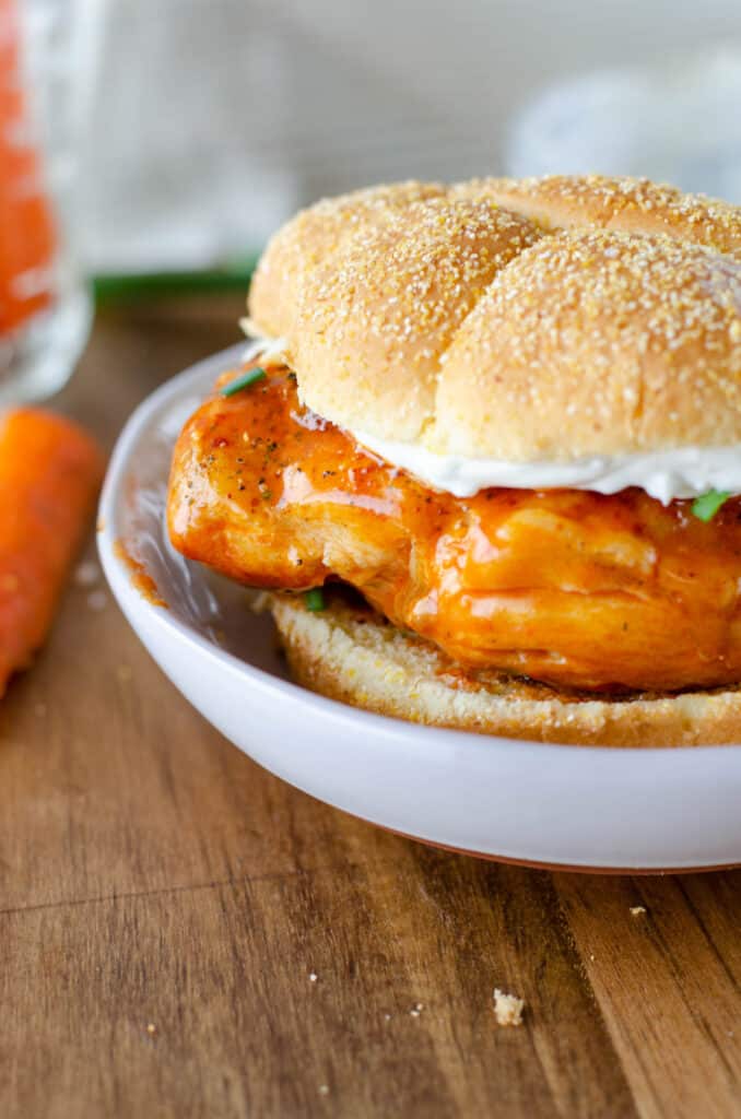 grilled buffalo chicken sandwich on a white plate.