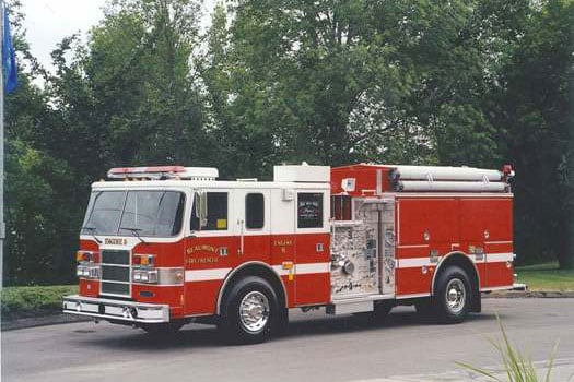 Pierce fire apparatus parked outside on a cloudy day surrounded by trees.