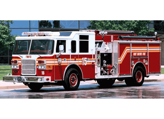 Driver’s side of a Pierce Manufacturing firetruck parked outside near a building. 