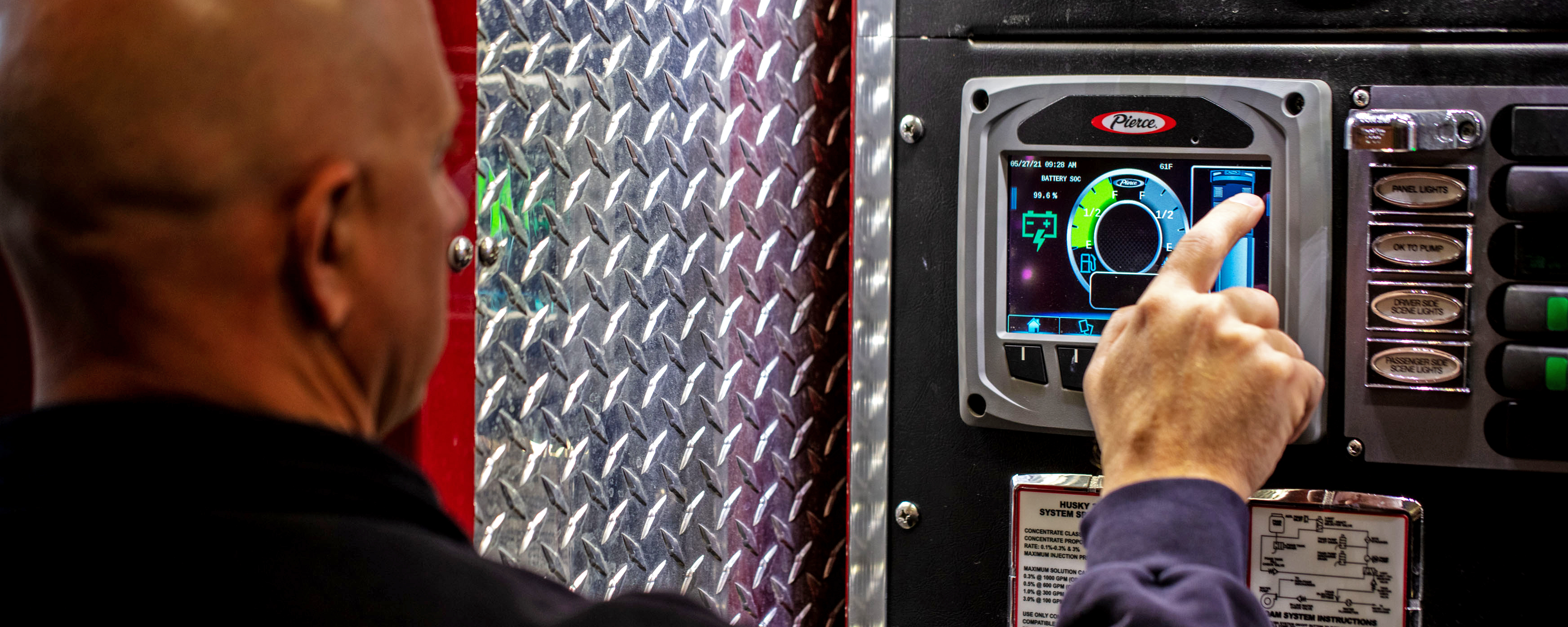 Firefighter servicing the charging station of a Pierce Volterra electric fire truck. 