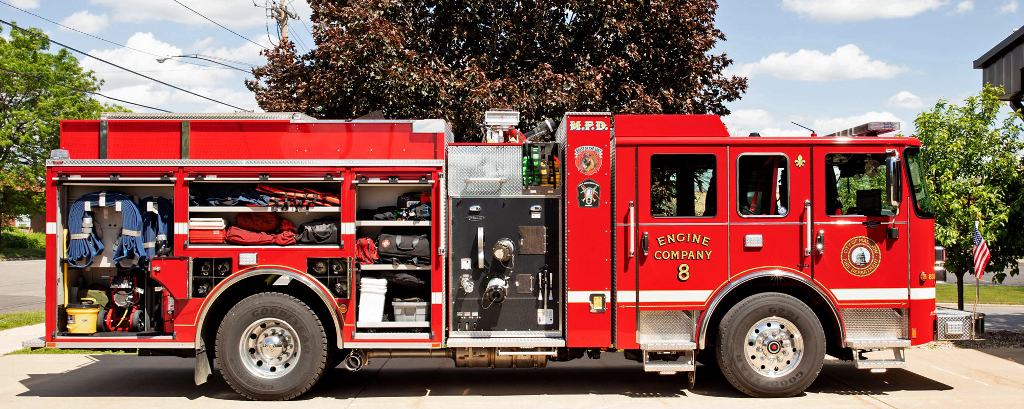 Passenger side of Pierce Volterra electric fire truck with the doors open showing storage space and compartments. 