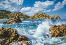 Ocean Desktop Wallpaper with a rocky coastline with waves splashing against the rocks.