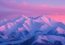 Winter HD Desktop Wallpaper with pink winter dawn over a snowy mountain range.