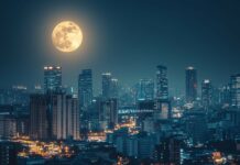 A stunning cityscape at night 1920x1080 Wallpaper with a brilliant full moon hanging over a bustling skyline, casting a gentle light on the city streets and buildings.